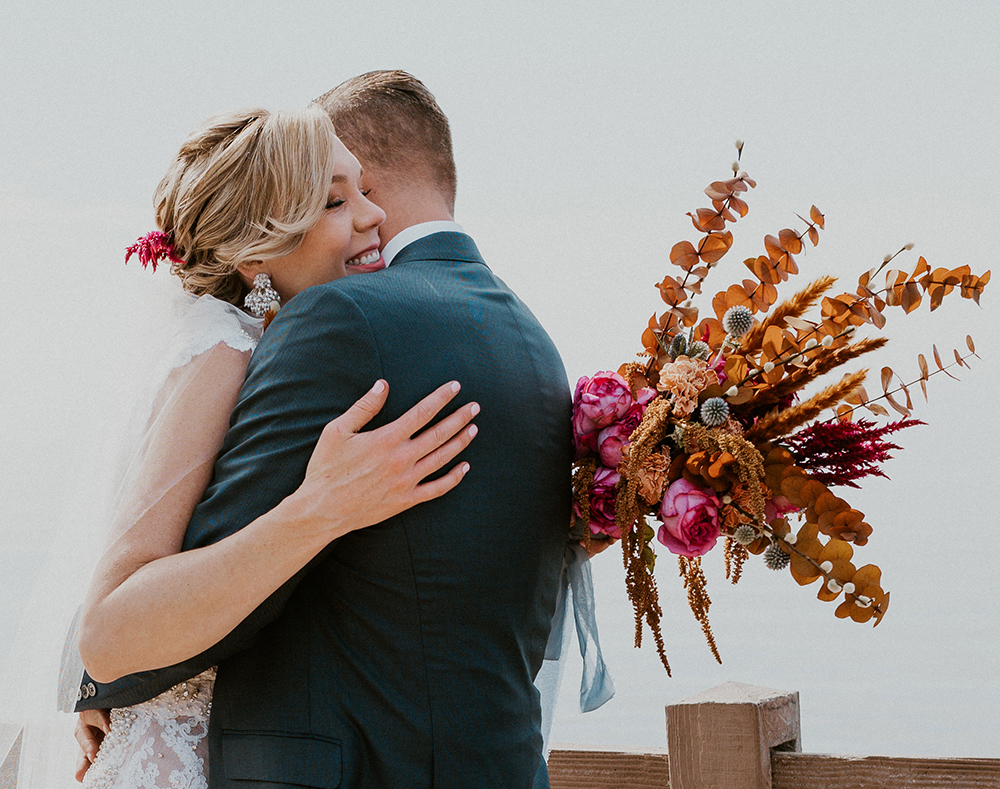 Blue Moon Dream DIY Wedding at Wayfarers Chapel in Palos Verdes, CA bride and groom embrace with bouquet palos verdes